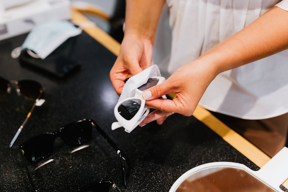 Person cleaning eyeglasses with microfiber cloth